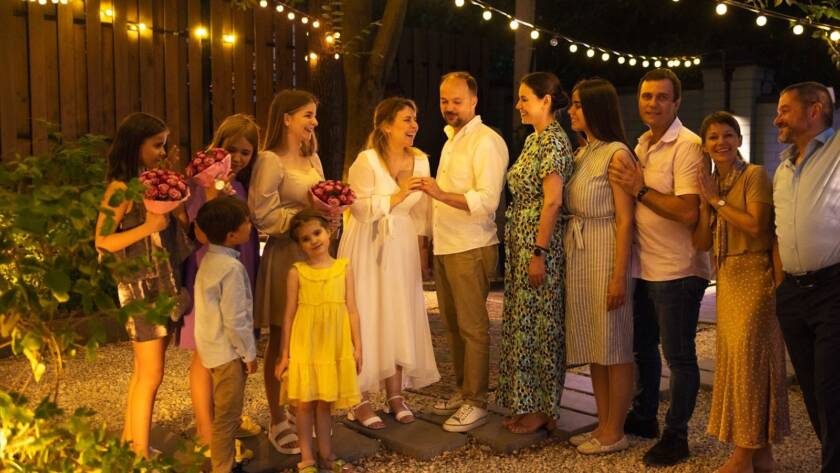 Bride and a groom surrounded by family at their micro wedding. 