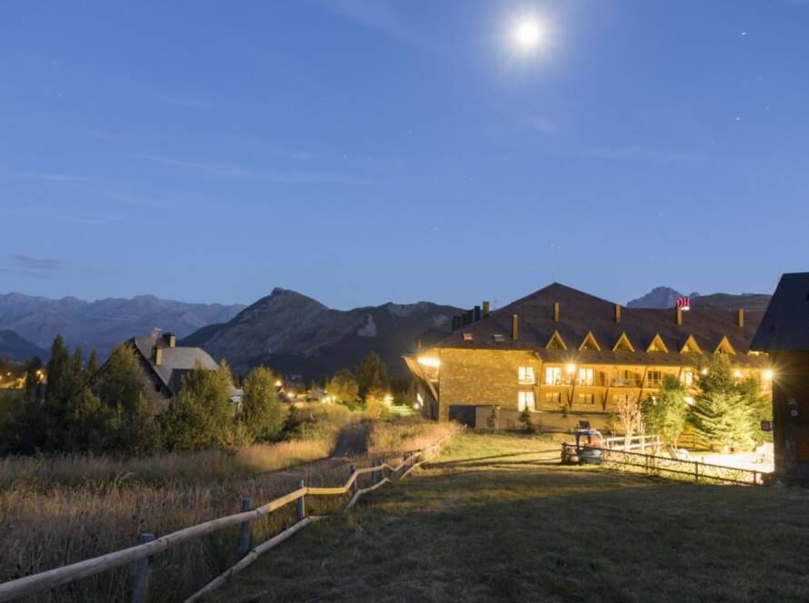 An illuminated rustic ranch venue at night, creating a cozy and inviting atmosphere for outdoor gatherings