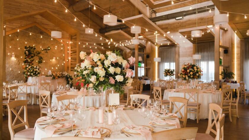 Floral arrangements and place settings in an event space for a wedding.
