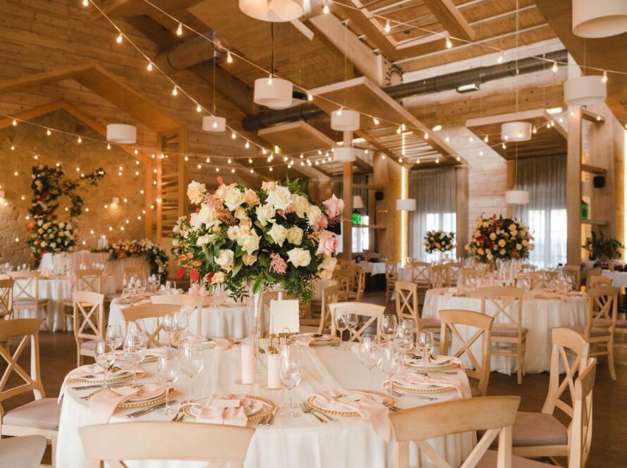 Floral arrangements and place settings in an event space for a wedding.