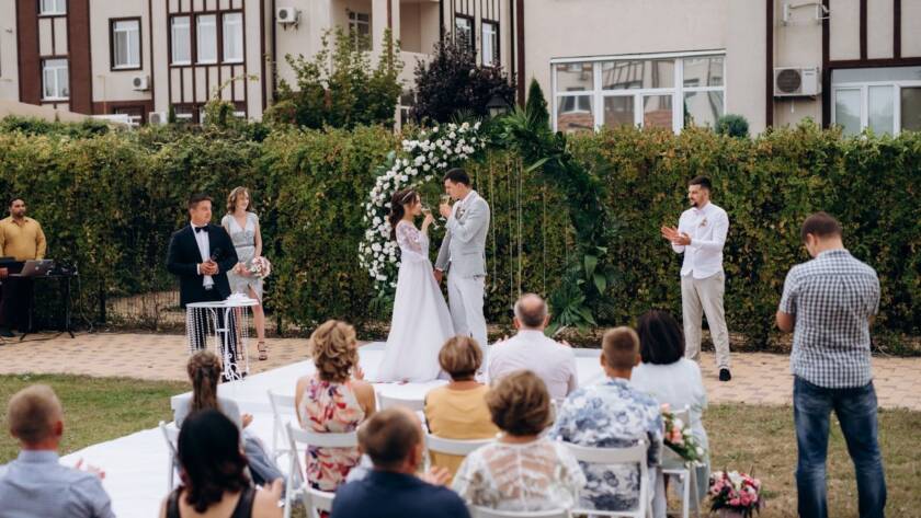 A small outdoor wedding ceremony on the glade with a close group of guests