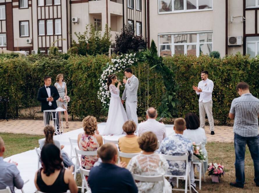 A small outdoor wedding ceremony on the glade with a close group of guests