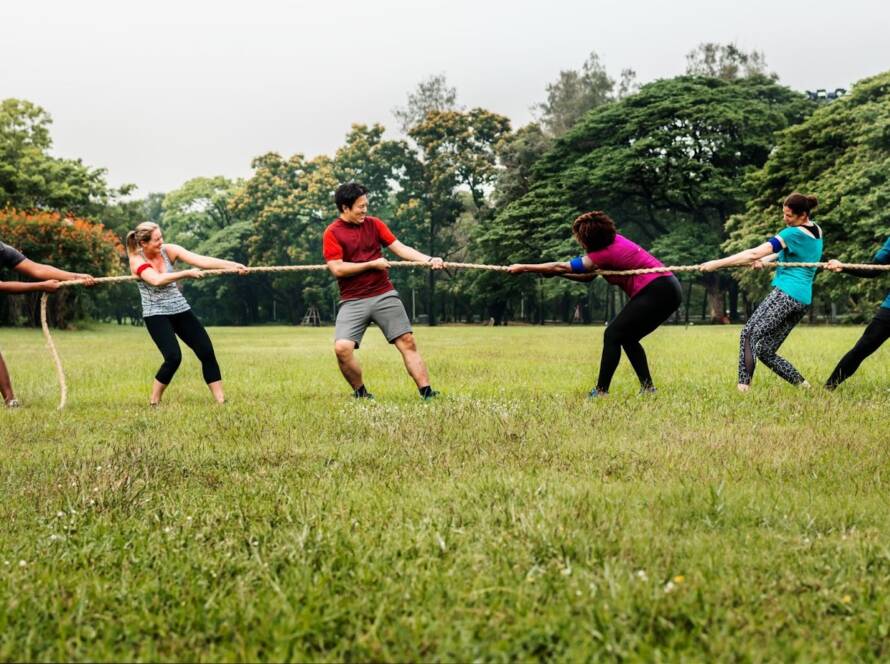 Colleagues participating in an outdoor tug of war during a corporate team building event