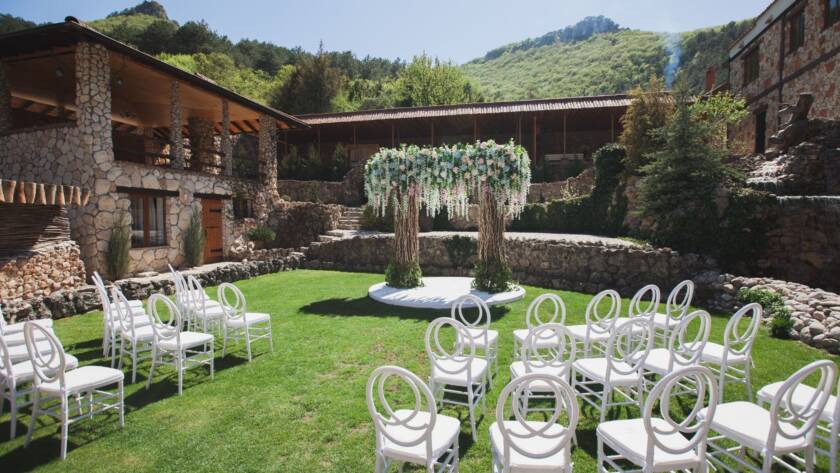 Outdoor wedding ceremony setup with elegant decor at a historic brick building with traditional architecture.