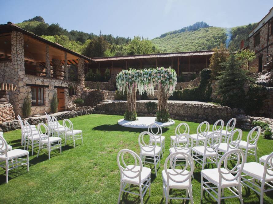 Outdoor wedding ceremony setup with elegant decor at a historic brick building with traditional architecture.