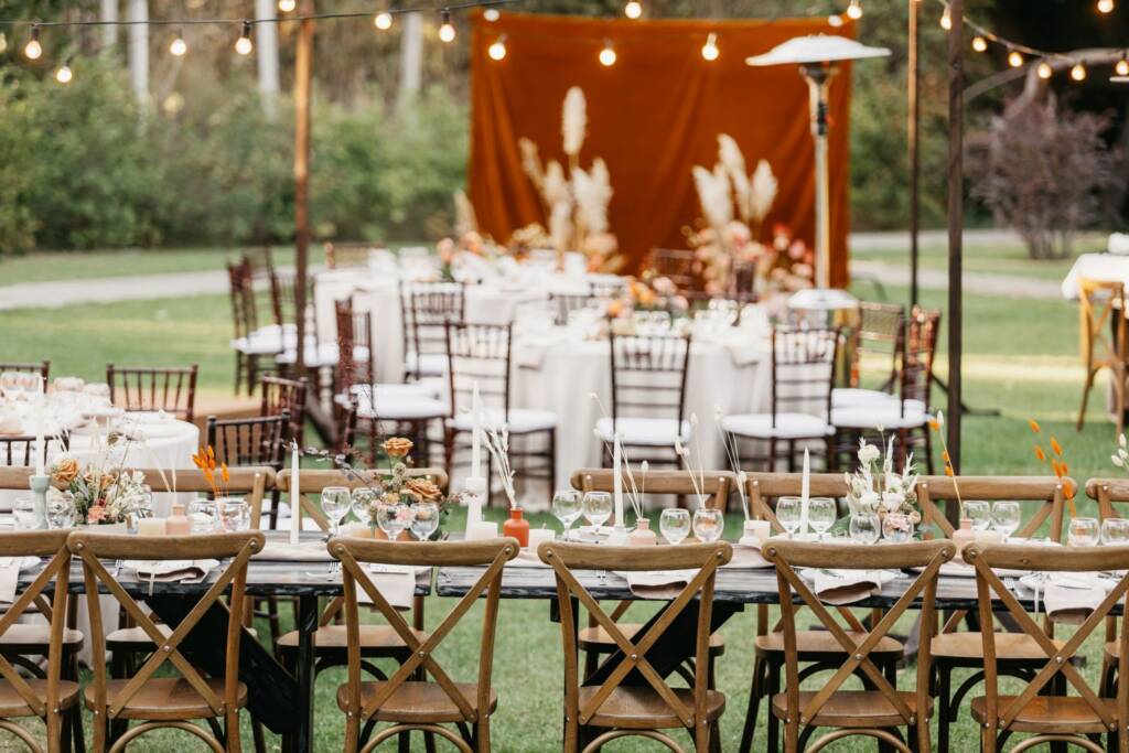 Elegant reception tables decorated for a rustic ranch wedding celebration outdoors