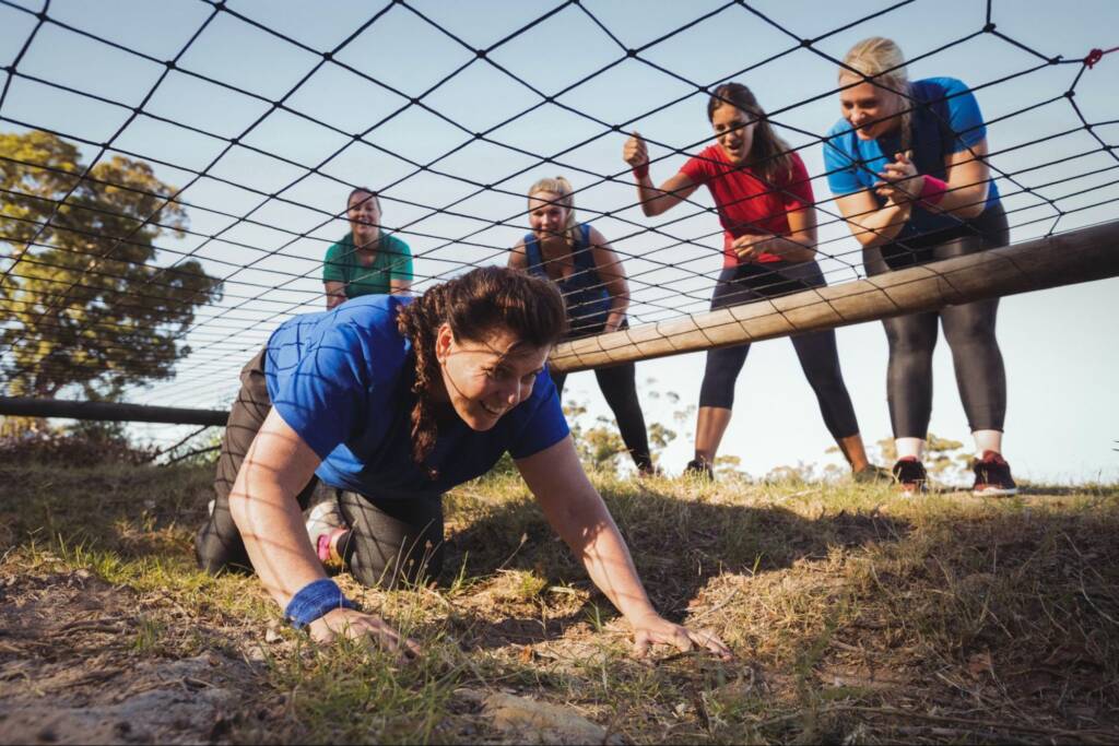 Corporate retreat participants completing an outdoor team-building obstacle course challenge together