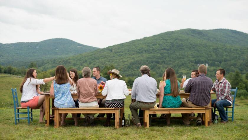 Corporate retreat attendees enjoying an outdoor meal with scenic mountain views during a team gathering