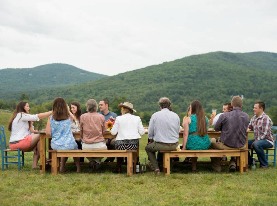 Corporate retreat attendees enjoying an outdoor meal with scenic mountain views during a team gathering